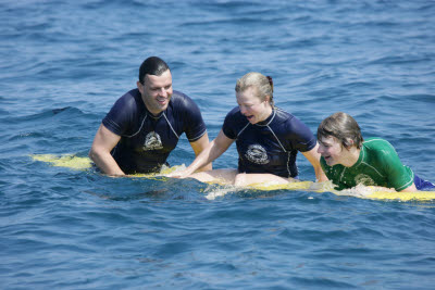 K.C., Lisa, and Alex posing on a Surfboard