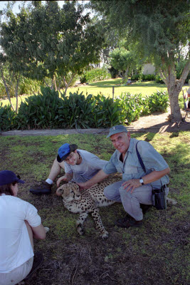 Andre, Mark, and Lisa hang out with a cheetah