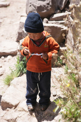 Kid plays with firecrackers, Tequile Island, Lake Titicaca, Peru